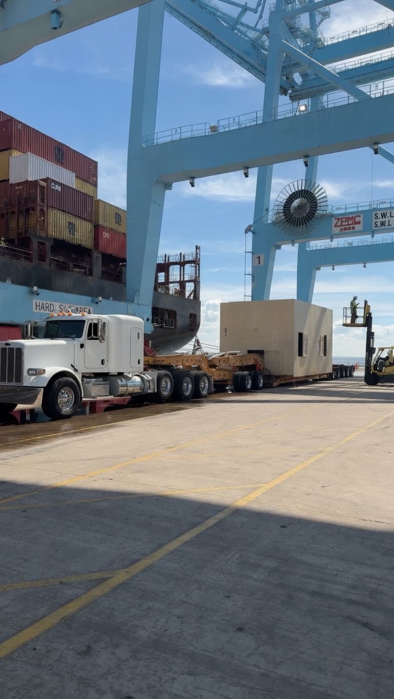 Oversized industrial equipment being transported through a port facility